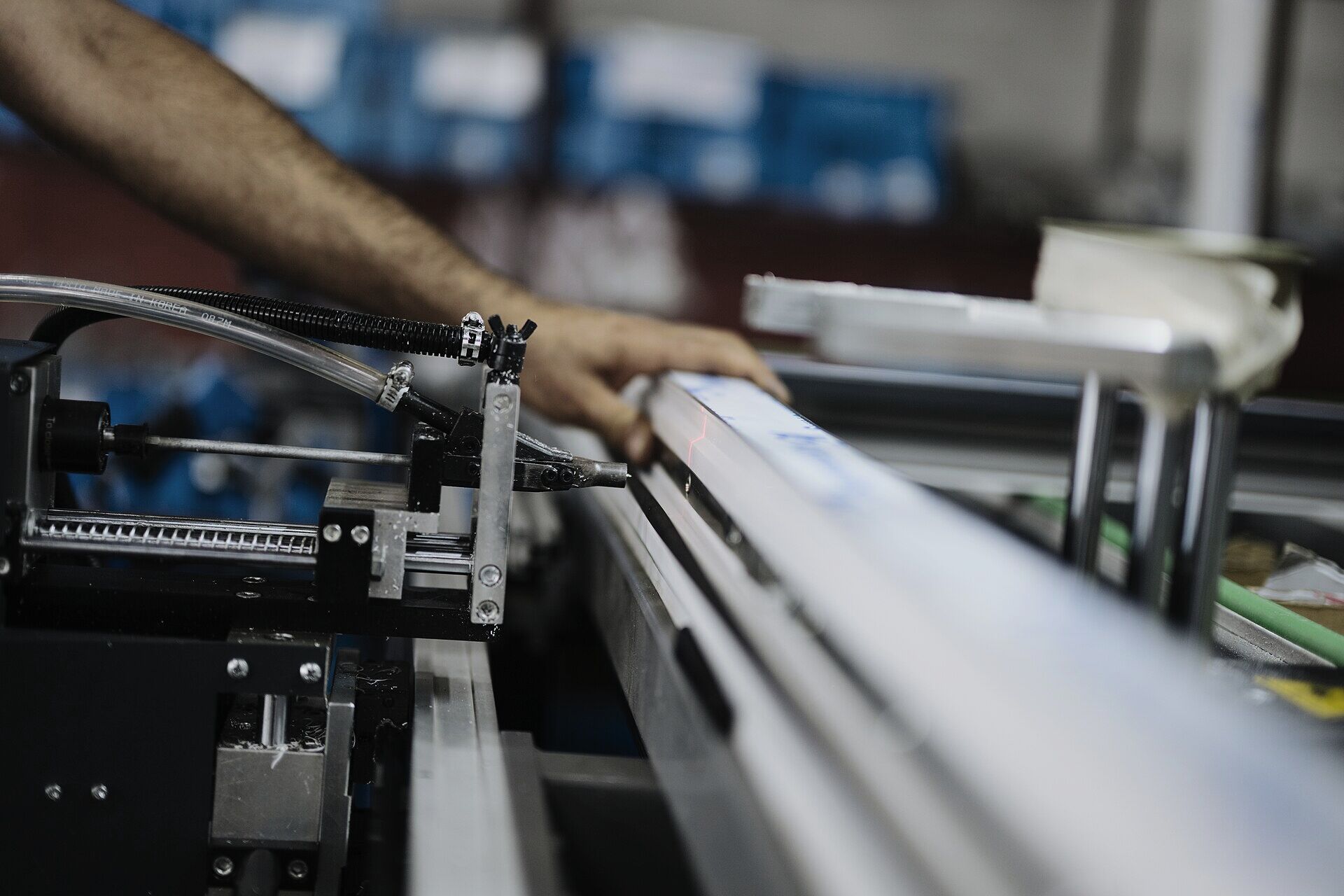 Operator working at machinery to assemble metal profile components (illustrative process photography, not a Kestrel facility)